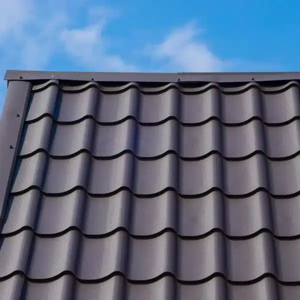Caballete de techo con tejas metálicas grises onduladas.