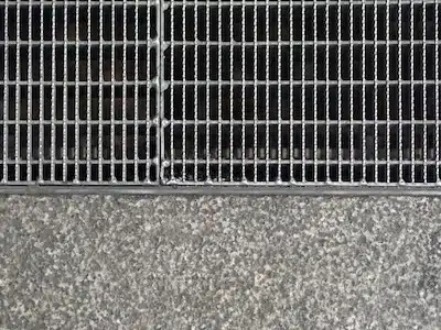 Parrilla metálica antideslizante instalada en suelo urbano, reforzando la seguridad peatonal en espacios públicos.