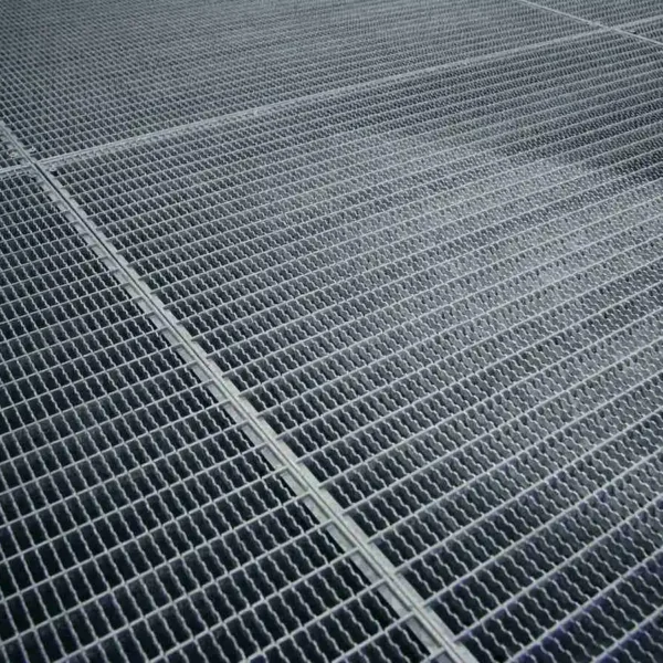 Parrilla metálica antideslizante de acero galvanizado, ideal para pisos industriales y zonas de alto tránsito.