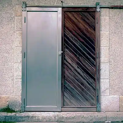 Imagen comparativa de puertas exteriores fabricadas con plancha galvanizada mostrando resistencia al deterioro y acabado profesional en instalación arquitectónica